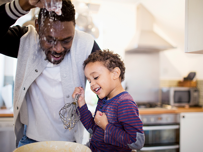 A father and his son baking together in the kitchen 